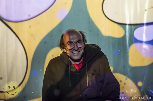 Bernd Koch, fundador da Psycholights, diante de uma parede coberta pelas suas próprias projeções.